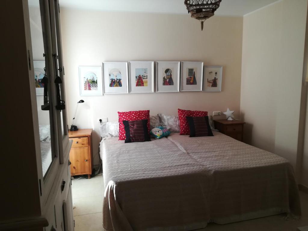 a bedroom with a bed with red and black pillows at Casa Rufas in Altea