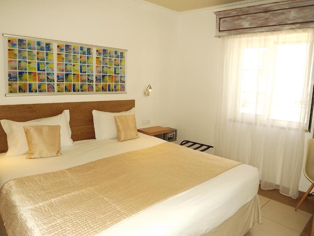 um quarto com uma cama e uma pintura na parede em Hotel Mar Azul em Lagos