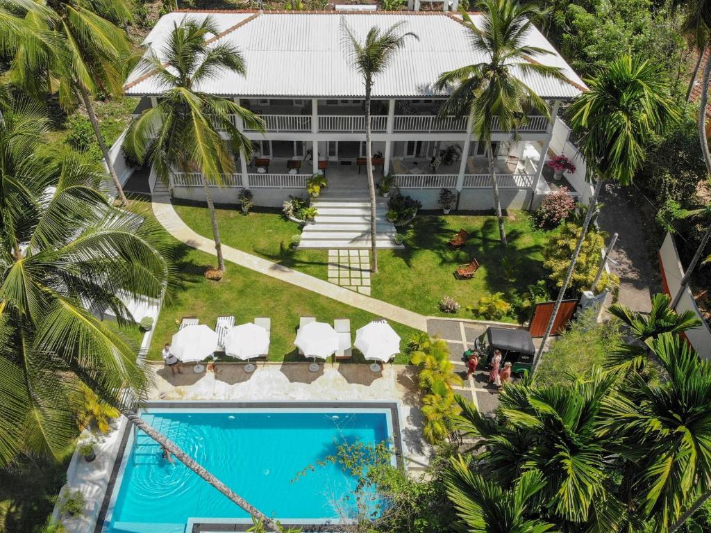 een luchtzicht op een resort met een zwembad en palmbomen bij Plantation House in Hikkaduwa