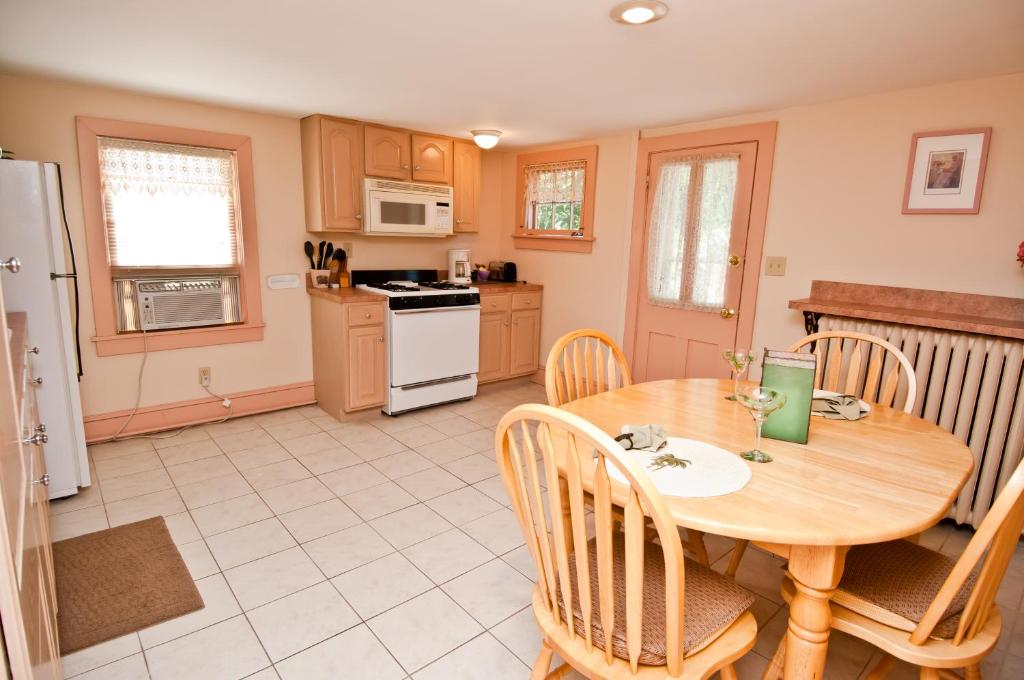 una cucina con un tavolo di legno e un tavolo e sedie di Thomas Webster House a Cape May