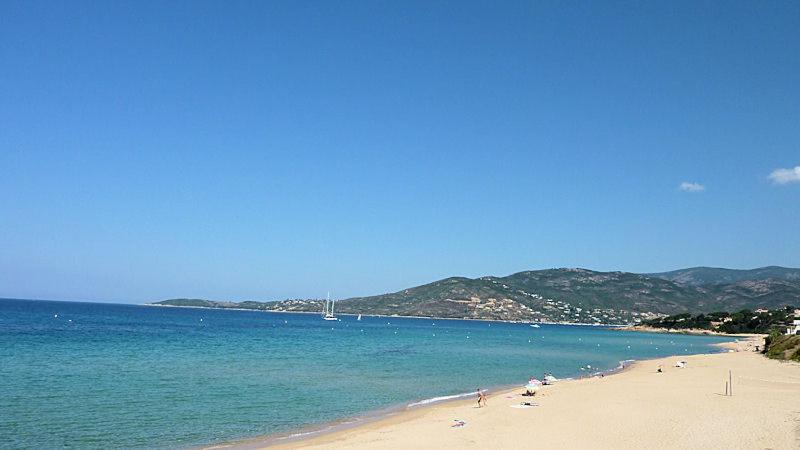 - une plage avec un groupe de personnes et l'océan dans l'établissement Maison de Vacances Renno, à Renno