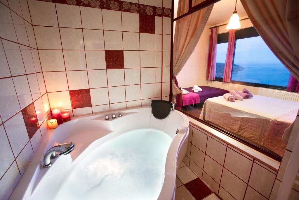 a bath tub in a bathroom with a bedroom at Aegean Panorama Apartments in Akhladherí