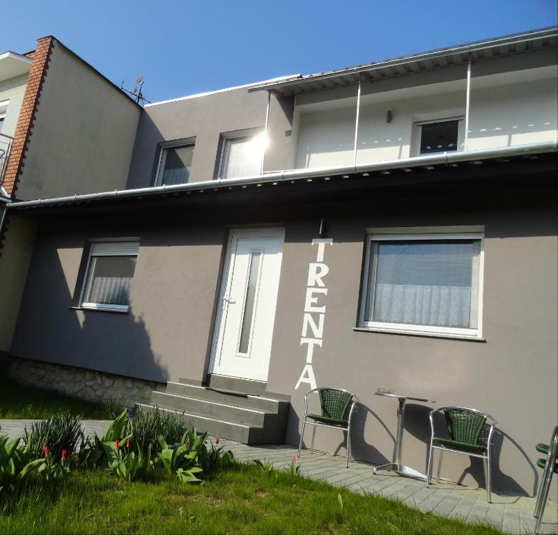 budynek z krzesłami i stołem przed nim w obiekcie Trenta Apartman Bükfürdő w mieście Bük