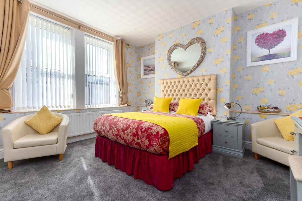 a bedroom with a bed and two chairs and a mirror at Valentine Lodge Over 25 Couples Only in Blackpool