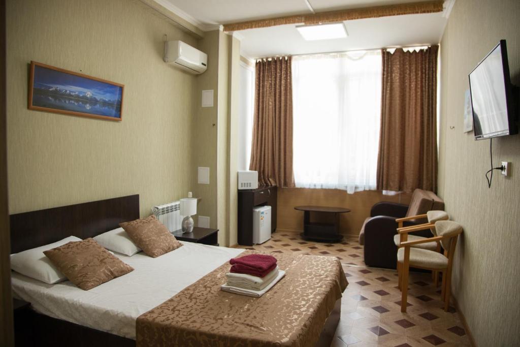 ソチにあるApartment Svetlana Kurortnyiのベッドと椅子付きのホテルルーム