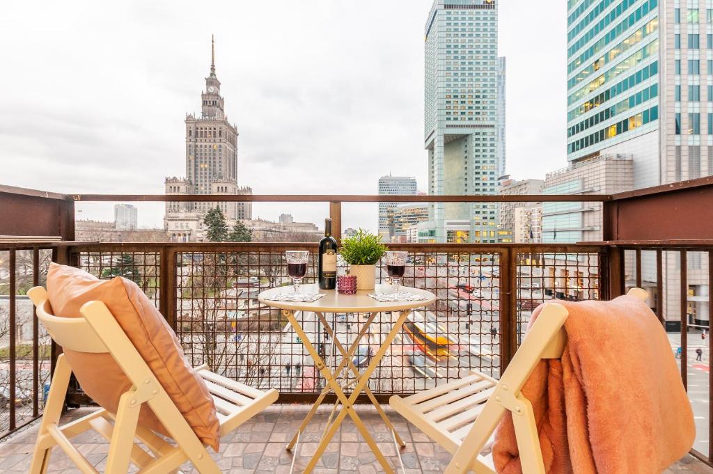 a balcony with a table and chairs with a view of the city at Apartments The View by Renters in Warsaw