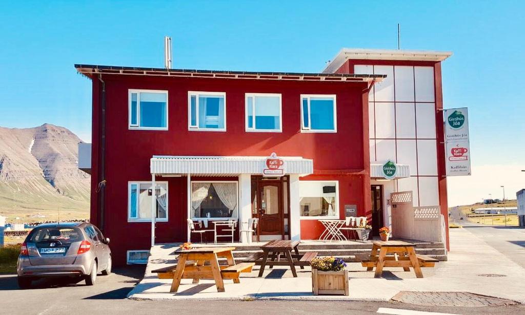 ÓlafsfjörðurKlara Guesthouse的前面有一张野餐桌的红色建筑