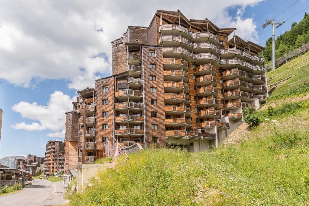 a tall brick apartment building on the side of a hill at Résidence Pierre &amp; Vacances Electra in Avoriaz