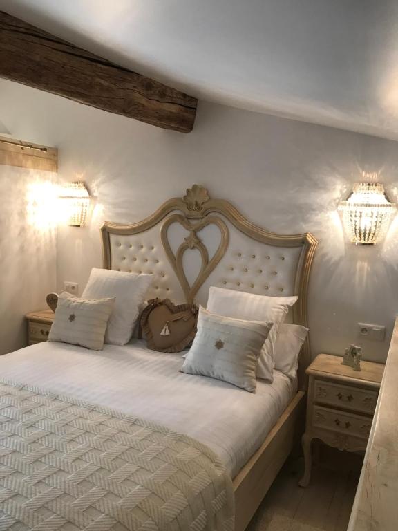 1 dormitorio con 1 cama grande con sábanas y almohadas blancas en Couvent des Carmes en Narbonne