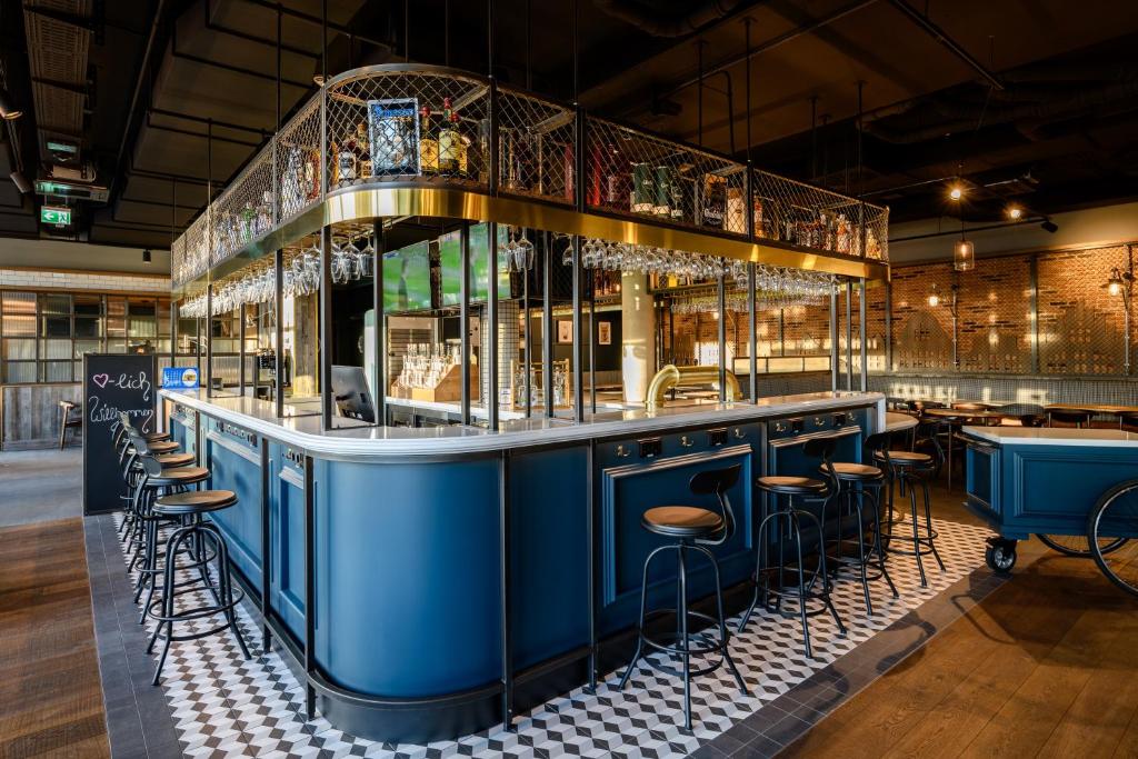 eine blaue Bar mit Hockern in einem Restaurant in der Unterkunft ibis Landshut City in Landshut