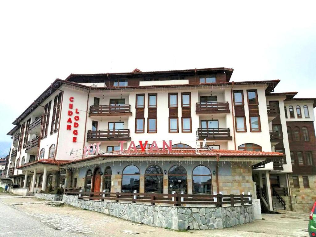 a large white building with a sign on it at Cedar Lodge 3/4 Apartment Paradise in Bansko