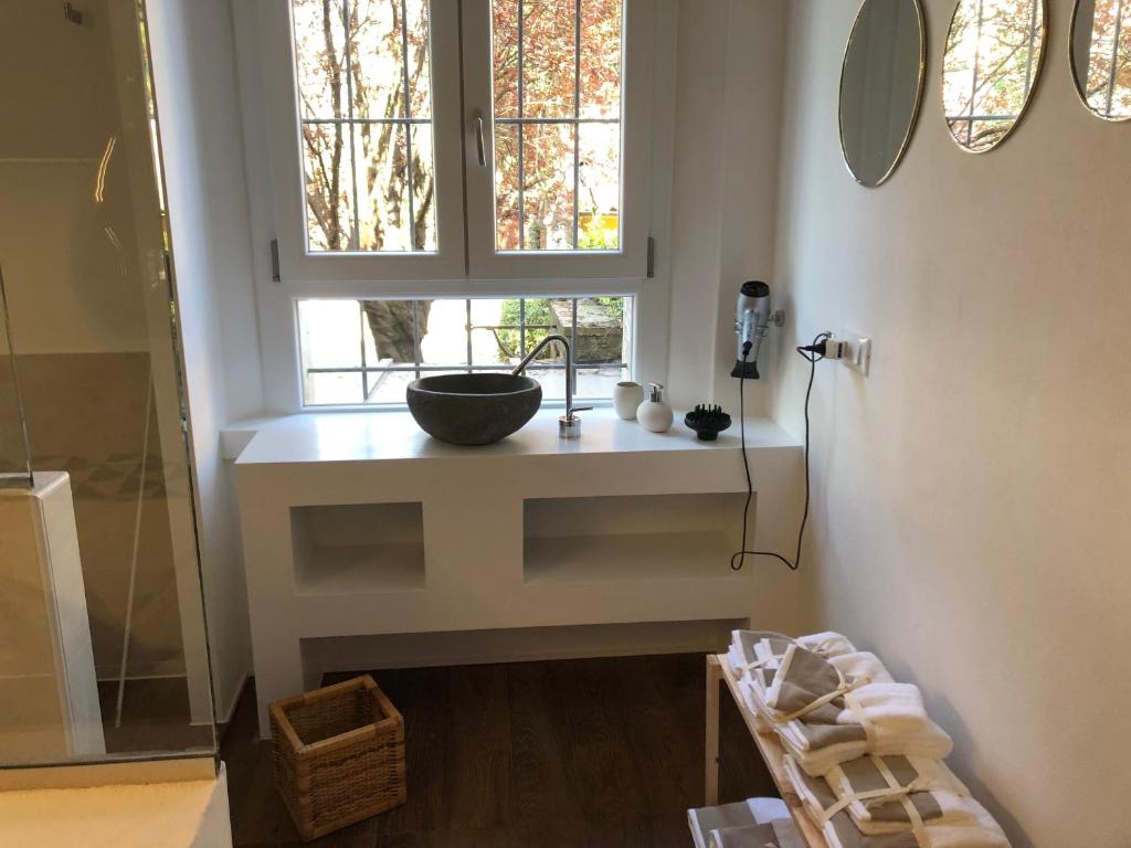 a bathroom with a sink on a counter with a window at Un Piccolo Rifugio in Ferrara