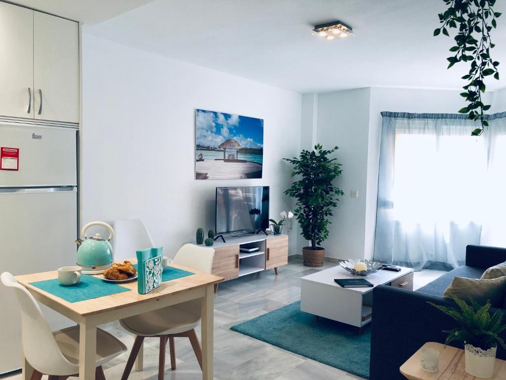 sala de estar con mesa y sofá en Luxury Doña Carlota, en Torremolinos