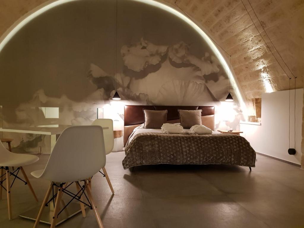 普利亞區格拉維納的住宿－Le Fornaci Imperial Lodge & Spa，卧室配有一张床和一张桌子及椅子