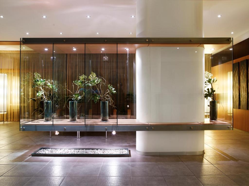 a lobby with plants in a glass case at Spetses Hotel in Spetses