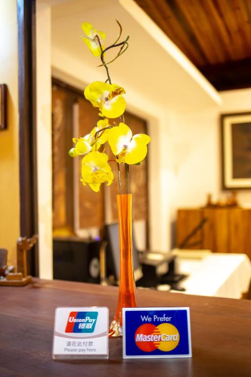 a vase with yellow flowers sitting on a table at Andasibe Lemurs Lodge in Andasibe