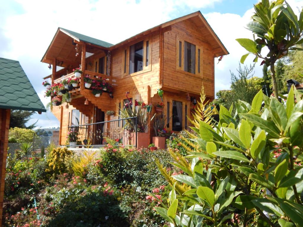 Villa Evelia في أكيتانيا: منزل خشبي مع ورود في الحديقة