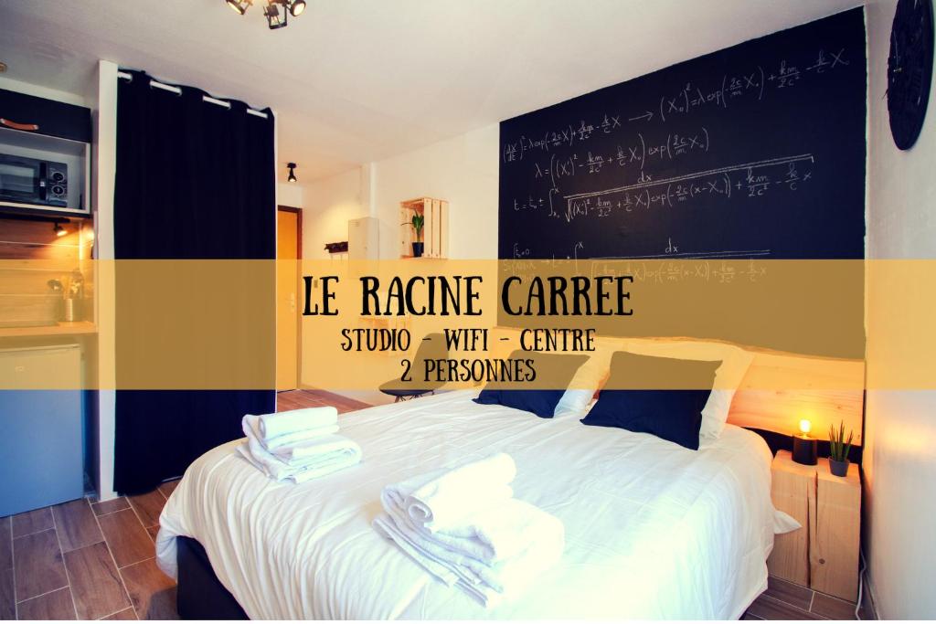 a bedroom with a bed with a chalkboard on the wall at LE RACINE CARREE - topbnb dijon in Dijon