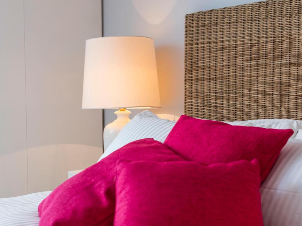 a bedroom with a pink blanket on a bed at Punta Ala Sea View Apartments in Punta Ala