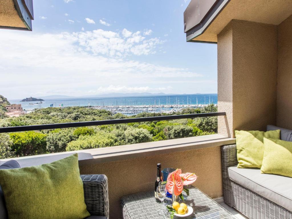 a balcony with a couch and a view of the ocean at Punta Ala Sea View Apartments in Punta Ala