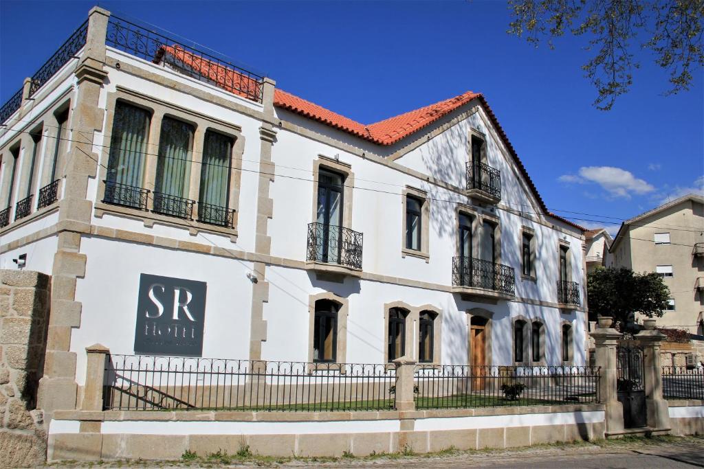 un viejo edificio blanco con un cartel en él en Hotel Solar do Rebolo en Oliveira do Hospital
