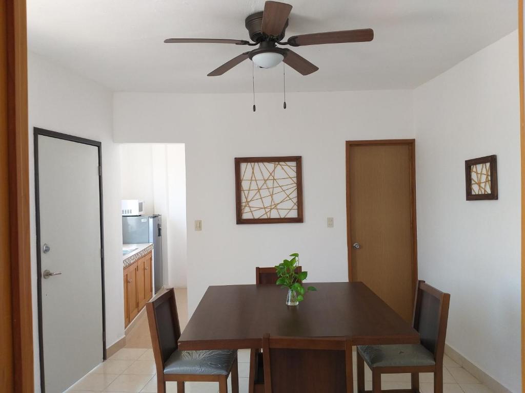 a dining room with a table and a ceiling fan at Depto Las Puertas la Ria #5 in Campeche