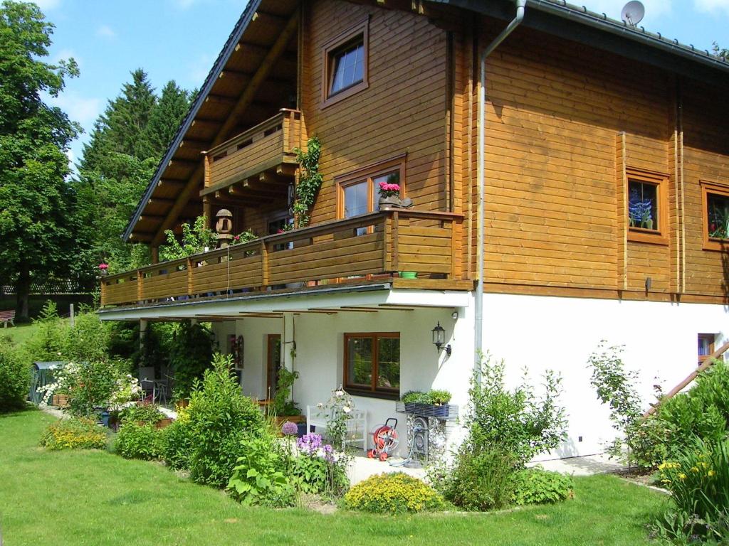 クラウスタール・ツェラーフェルトにあるFerienwohnung im Harz-Haus-Brunsの木造の家屋で、バルコニーが付いています。
