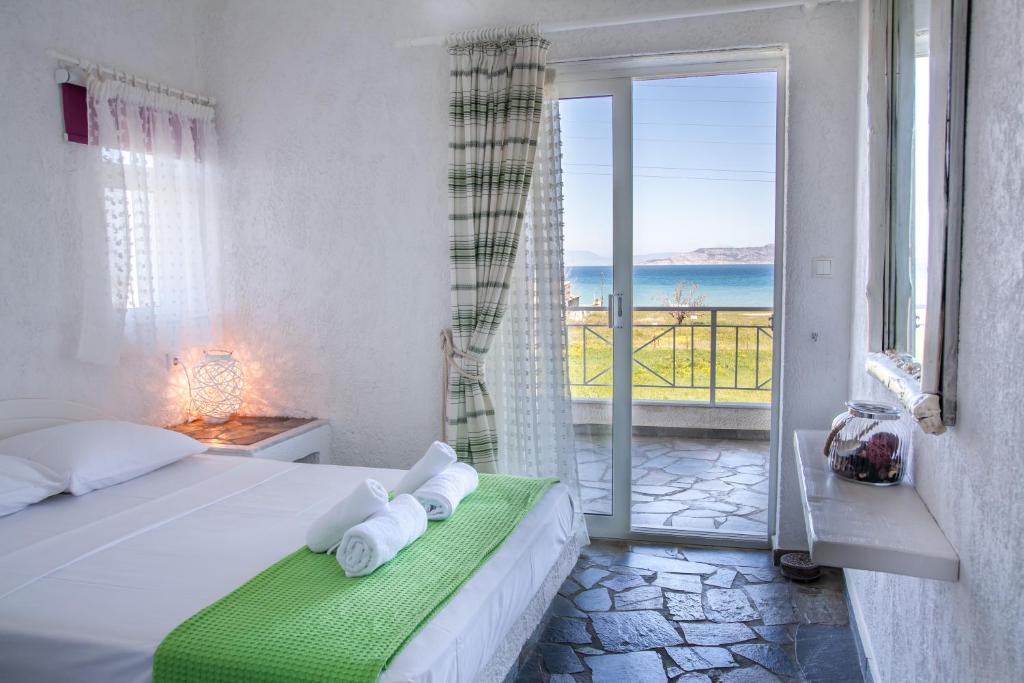 a bedroom with a bed with a view of the ocean at Phoenix Beachside Condos in Kokóni