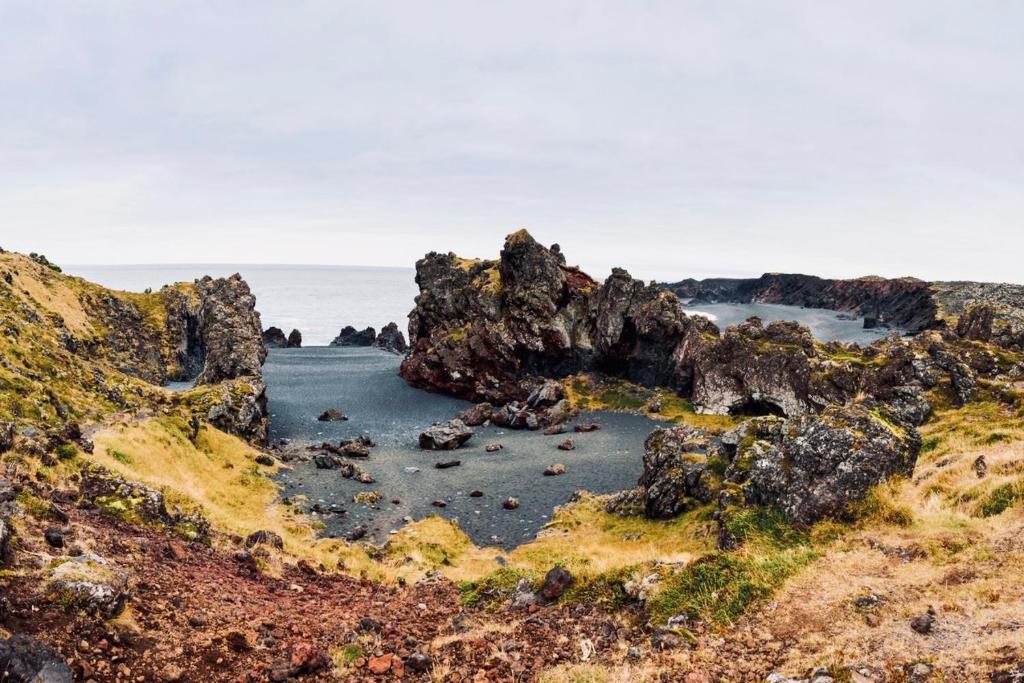 an island in the ocean with rocks in the water at Experience Beautiful Iceland in Ólafsvík