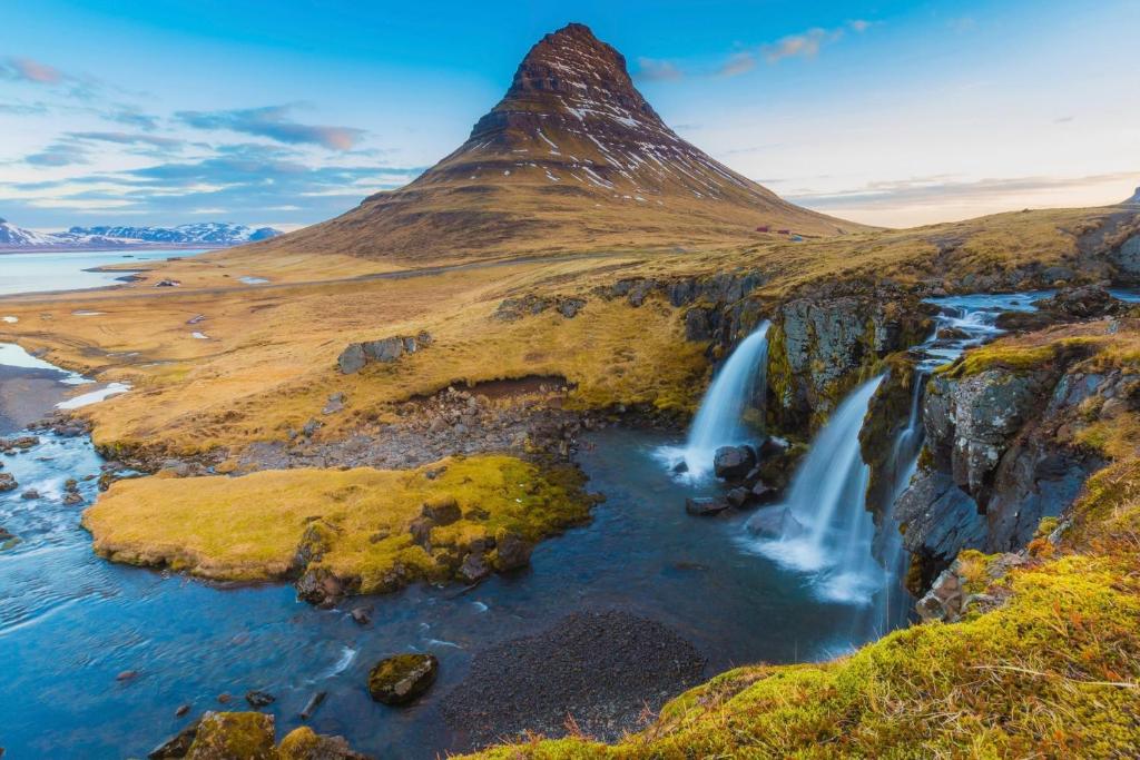 a mountain with two waterfalls on a cliff at Experience Beautiful Iceland in Ólafsvík