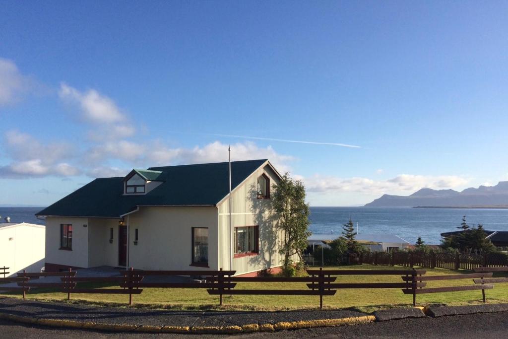 a small white house with a black roof at Experience Beautiful Iceland in Ólafsvík