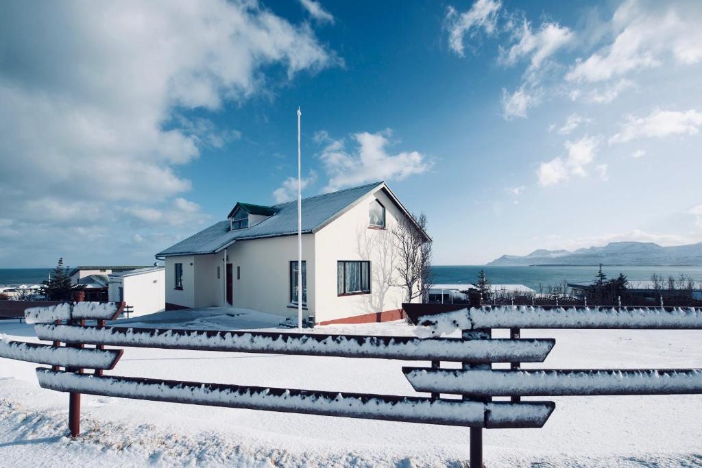 a house in the snow with a bench in front of it at Experience Beautiful Iceland in Ólafsvík