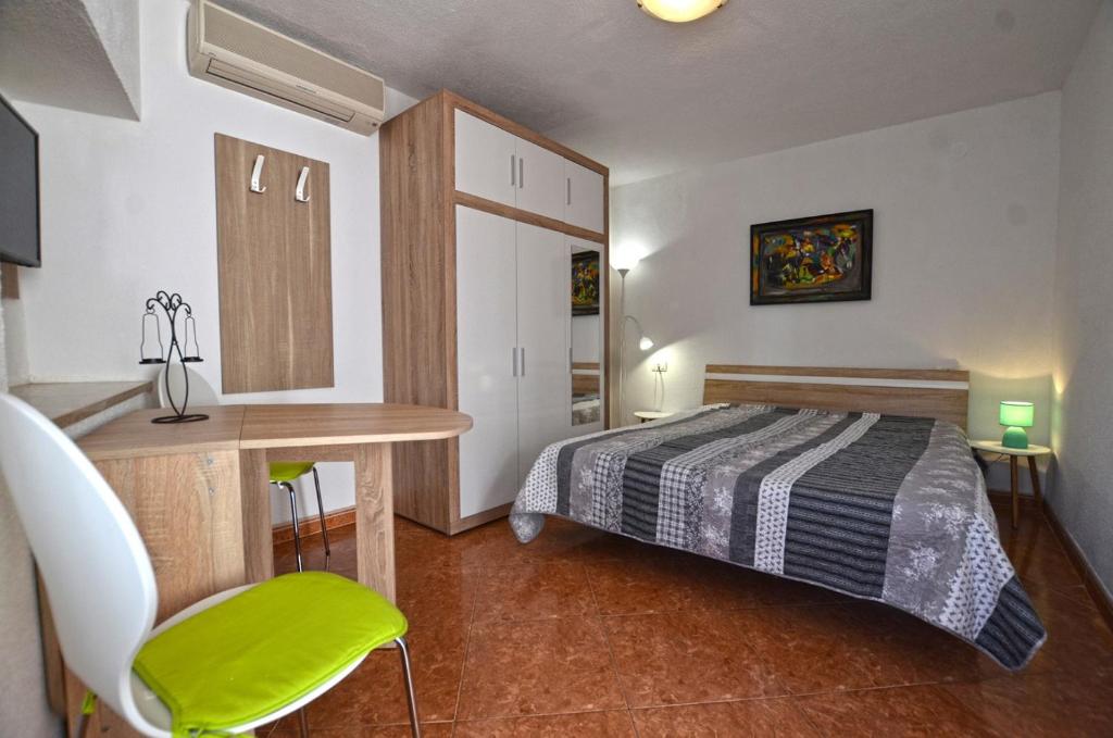 a bedroom with a bed and a table and a desk at Yulia Apartments in Rovinj