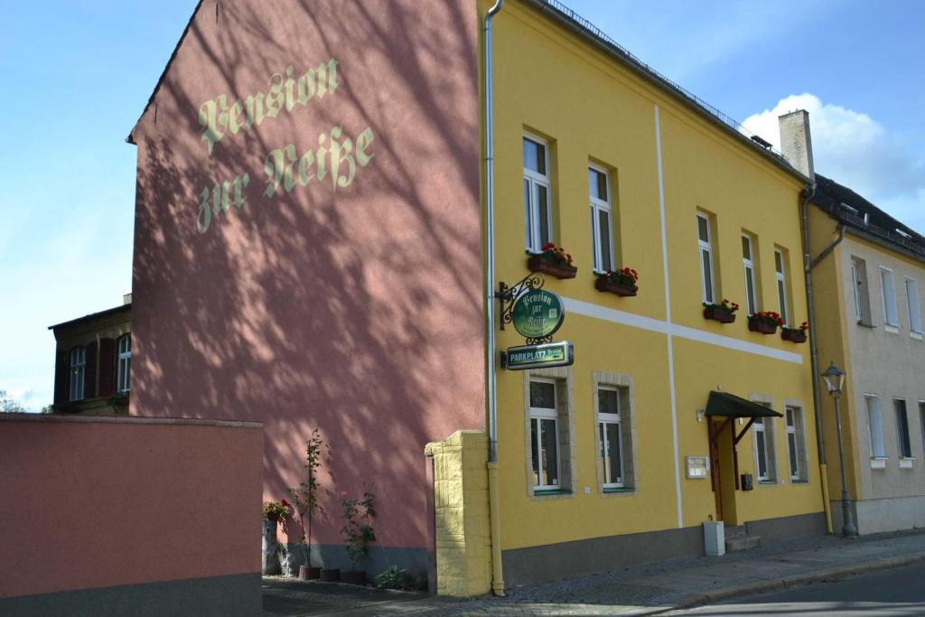 a yellow building on the side of a street at Pension zur Neiße in Guben
