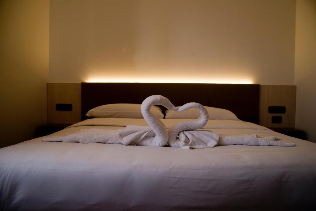 twee zwanen maken een hart op een bed bij Albergo RISTORANTE SOTTOCASTELLO in Cassacco