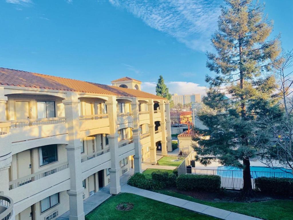 an apartment building with a tree in the yard at Good Nite Inn Fremont in Fremont