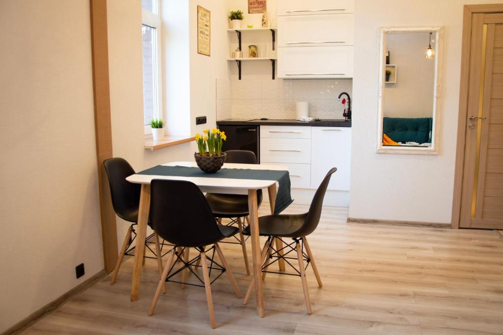 uma cozinha e sala de jantar com mesa e cadeiras em LUCKY 7 apartment em Liepāja