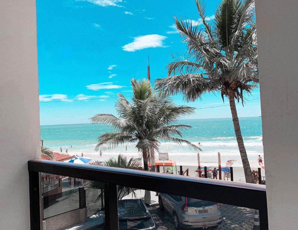 een balkon met uitzicht op het strand en de palmbomen bij Pousada Sol e Mar Ingleses in Florianópolis