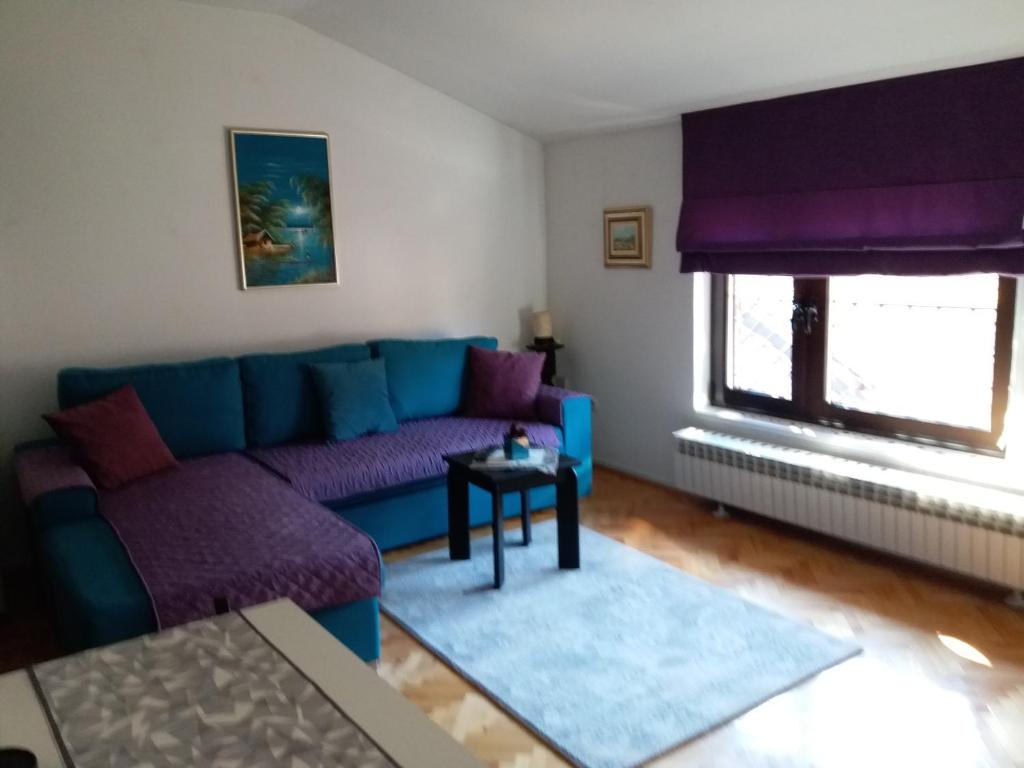sala de estar con sofá azul y mesa en Cozy apartment Aya in Old town Sarajevo en Sarajevo