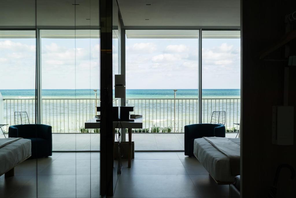 a room with two beds and a view of the ocean at Posia Retreat & Spa UNA Esperienze in San Foca