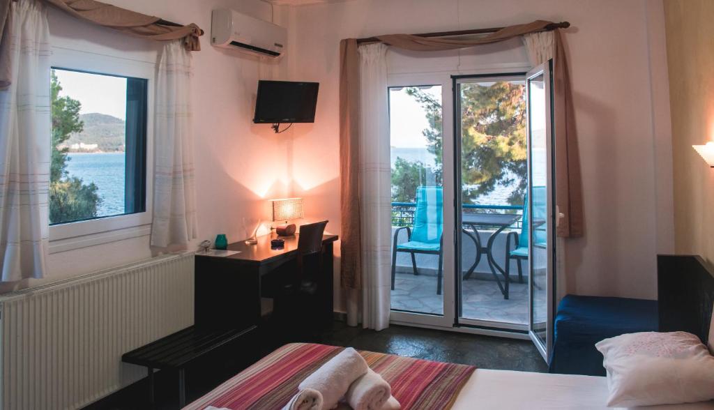 sypialnia z łóżkiem oraz balkon ze stołem w obiekcie Sirius Apartments w mieście Neos Marmaras