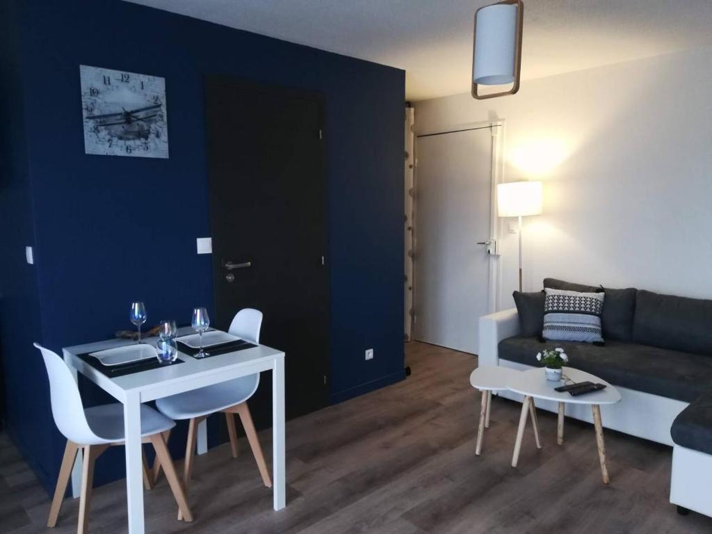 a living room with a table and a couch at Appartement Cosy proche Météo France et Airbus in Toulouse