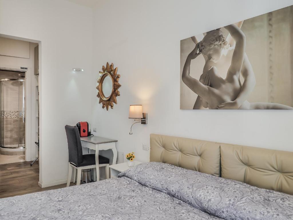 ラ・スペツィアにあるAffittacamere Raggio di Soleのベッドルーム1室(ベッド1台付)が備わります。壁に絵が飾られています。