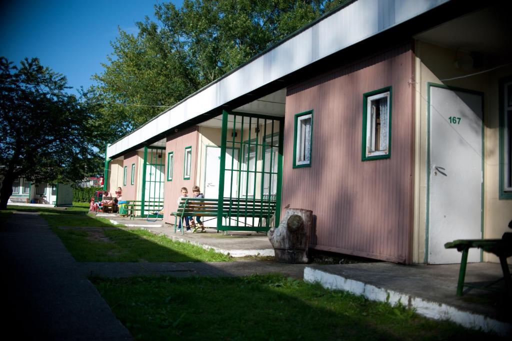 a building with people sitting on a bench next to it at OW Gromada Pod Topolami in Międzyzdroje