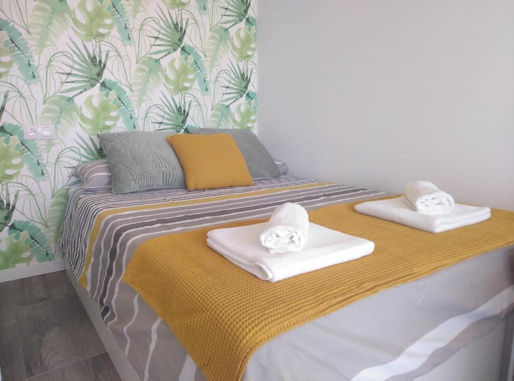 - un lit avec 2 serviettes dans l'établissement BSB Surf&Beach Apartment Salou, à Salou