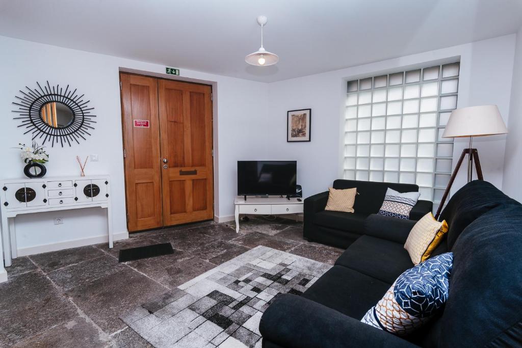 a living room with a couch and a television at Fortaleza do Pico Apartment in Funchal