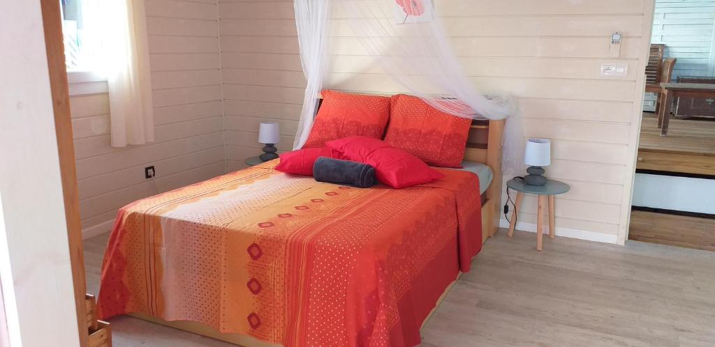 a bedroom with a bed with red pillows at bel ti kay in Les Anses-dʼArlets