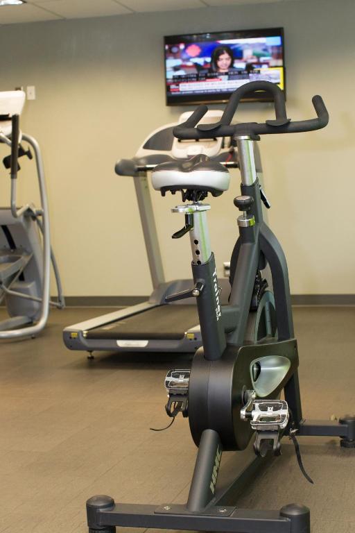 a treadmill in a gym with a tv in the background at Coast Hotel & Convention Centre in Langley