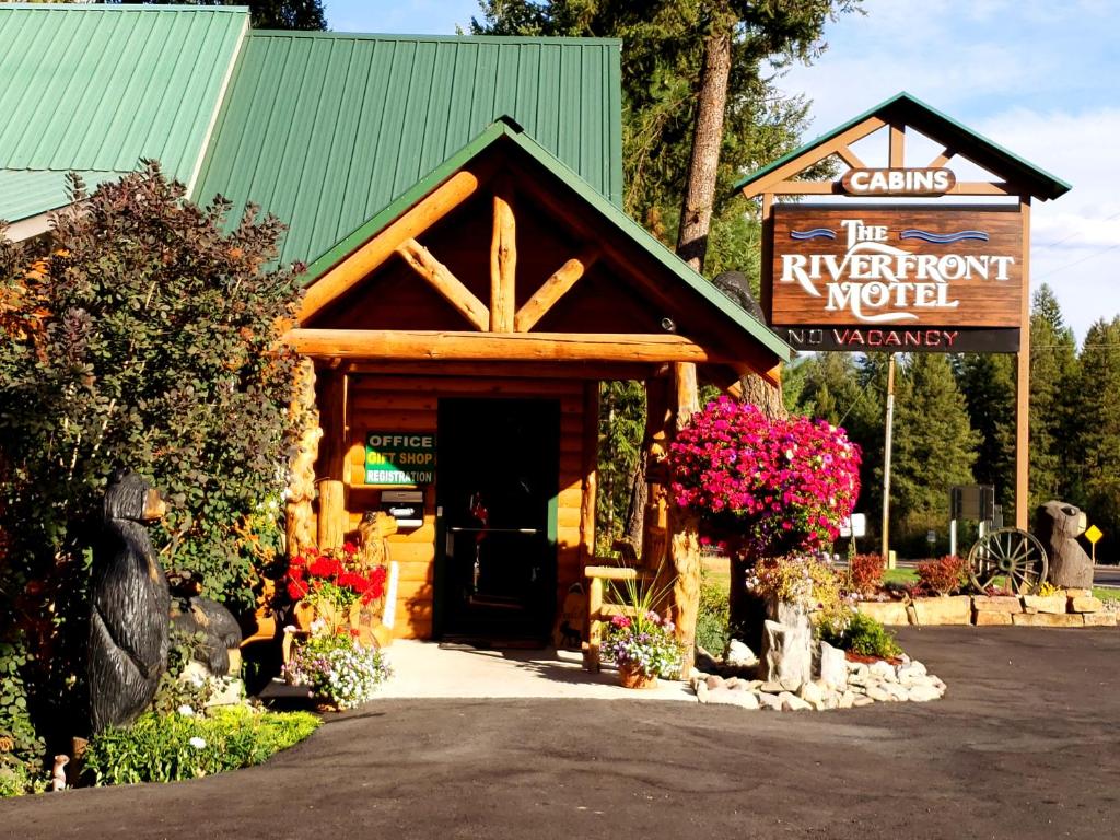 un bâtiment en bois avec un panneau en face de celui-ci dans l'établissement Riverfront Motel & Cabins, à Thompson Falls