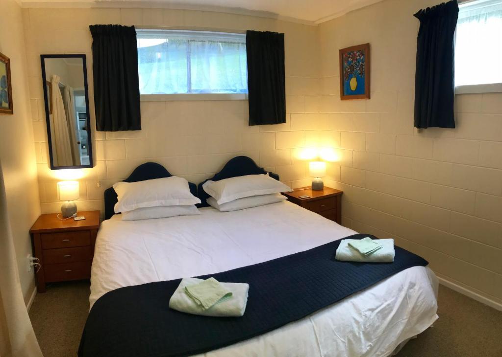 Perfect Base in the Bay Of Islands في Opua: غرفة نوم بسريرين عليها مناشف